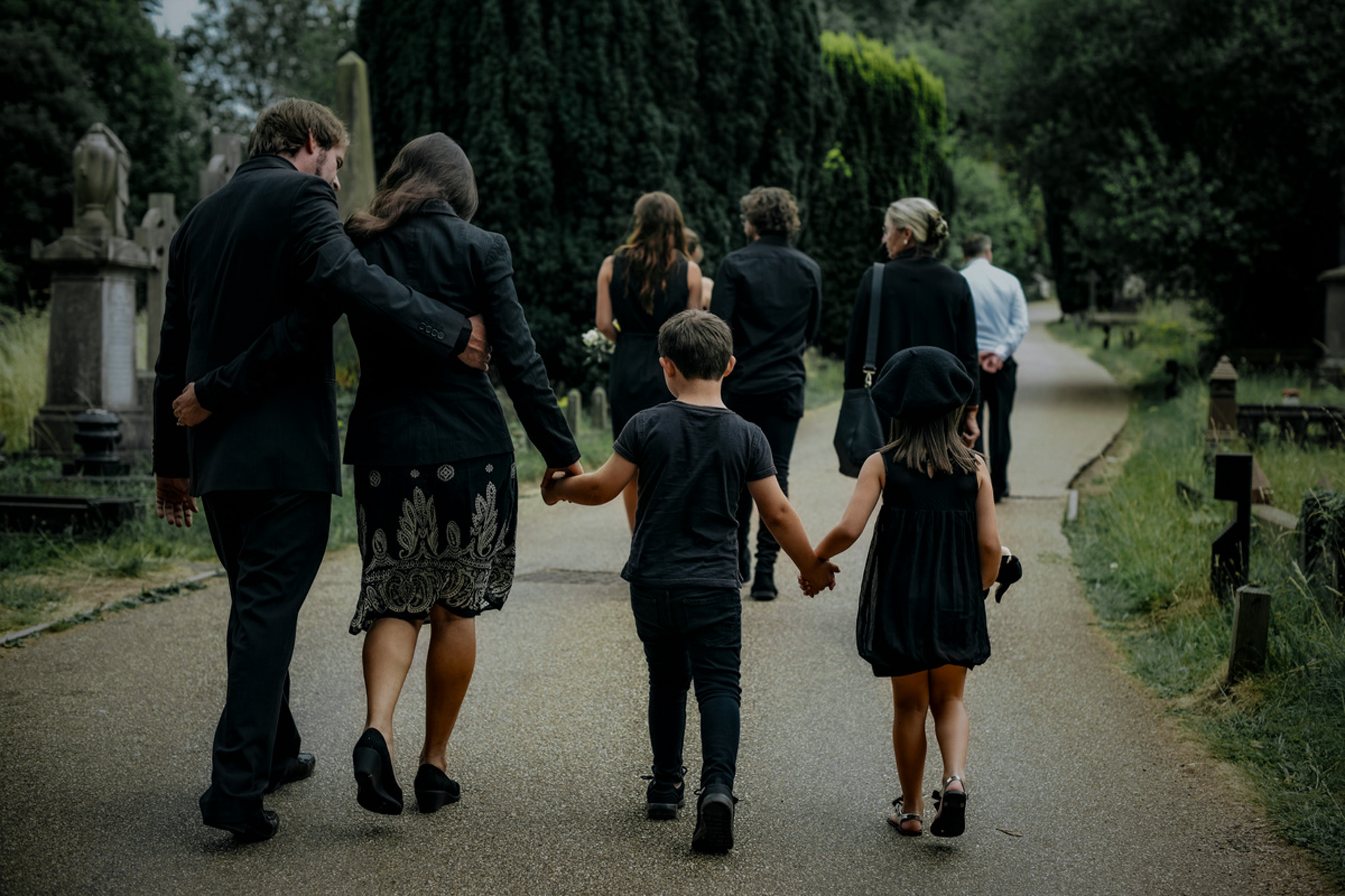 Grieving family walking through a cemetery
